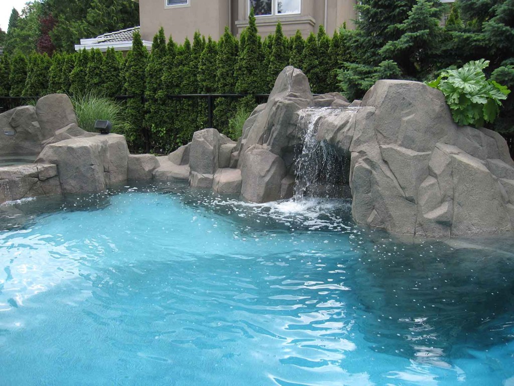 Luxury custom designed swimming pool with artificial rock wall surround