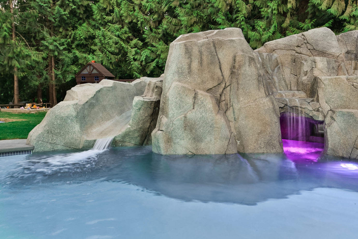 Concrete waterfall feature with swimming pool and colour changing LED swimming pool lights